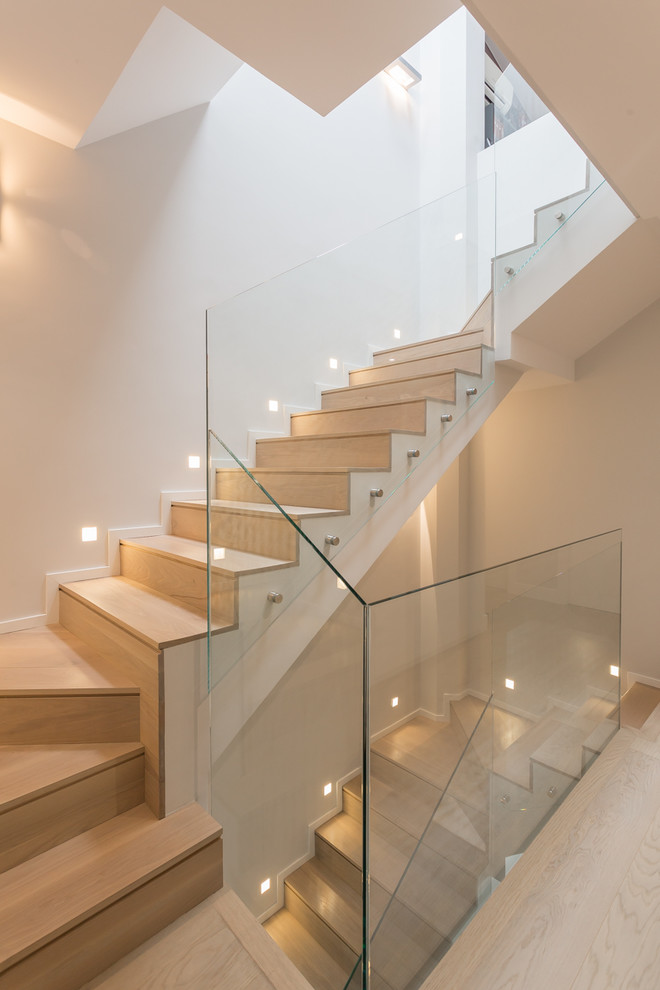 На фото: п-образная деревянная лестница в современном стиле с деревянными ступенями и стеклянными перилами