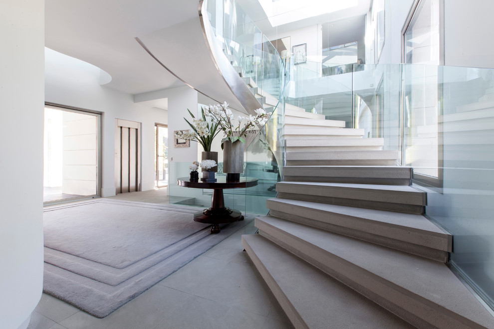 Large contemporary concrete curved staircase in Madrid with concrete risers.