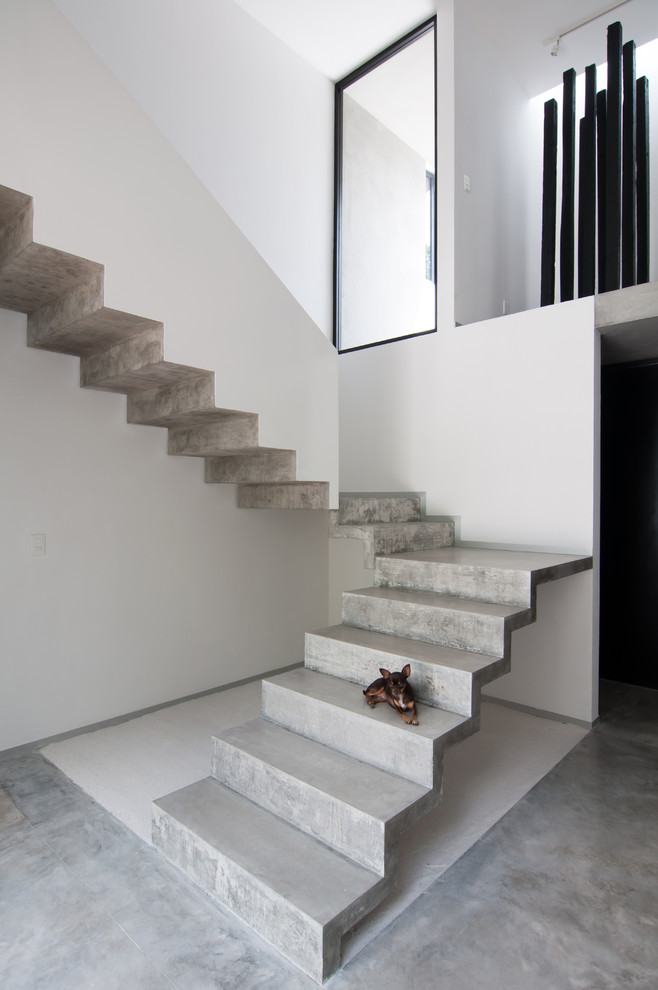 Réalisation d'un escalier minimaliste en L et béton avec des contremarches en béton.