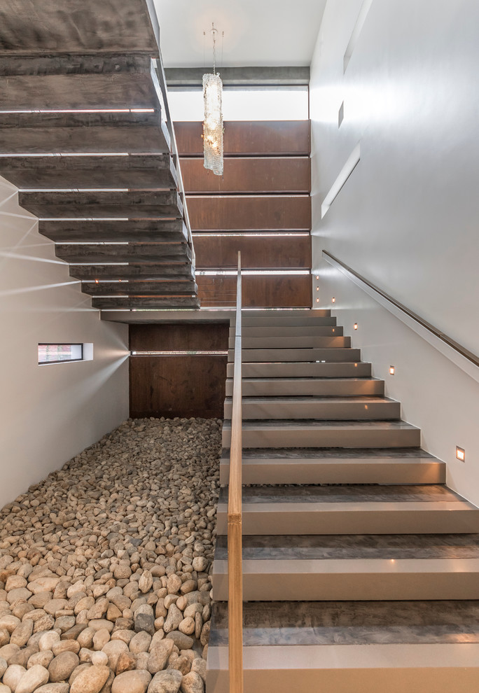 Ejemplo de escalera suspendida contemporánea extra grande con escalones de hormigón y contrahuellas de hormigón
