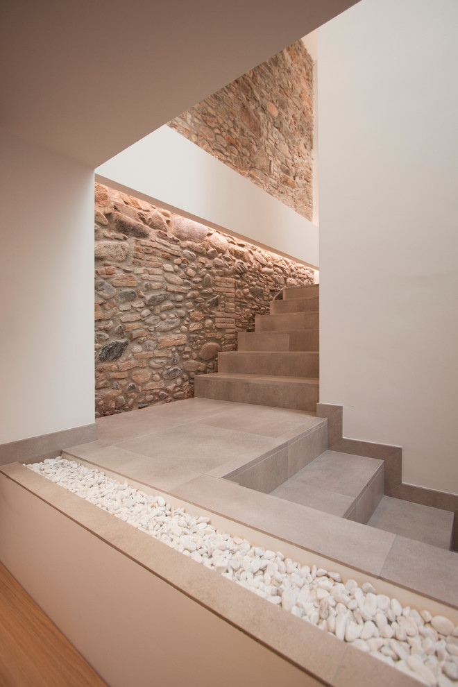 Idée de décoration pour un escalier carrelé design en L de taille moyenne avec des contremarches carrelées.