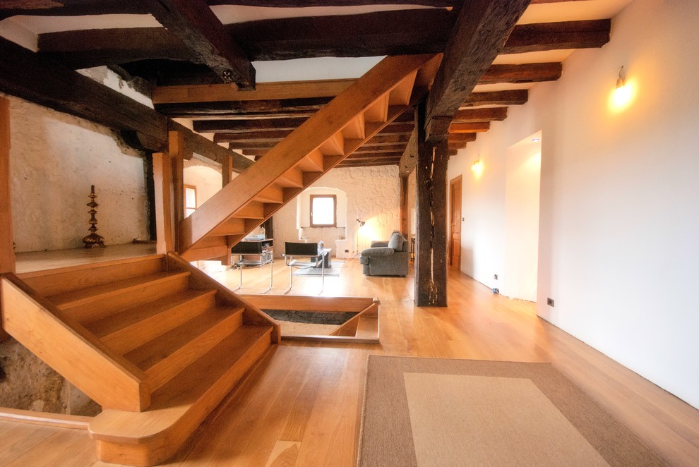 Foto de escalera en U rústica de tamaño medio con escalones de madera y contrahuellas de madera