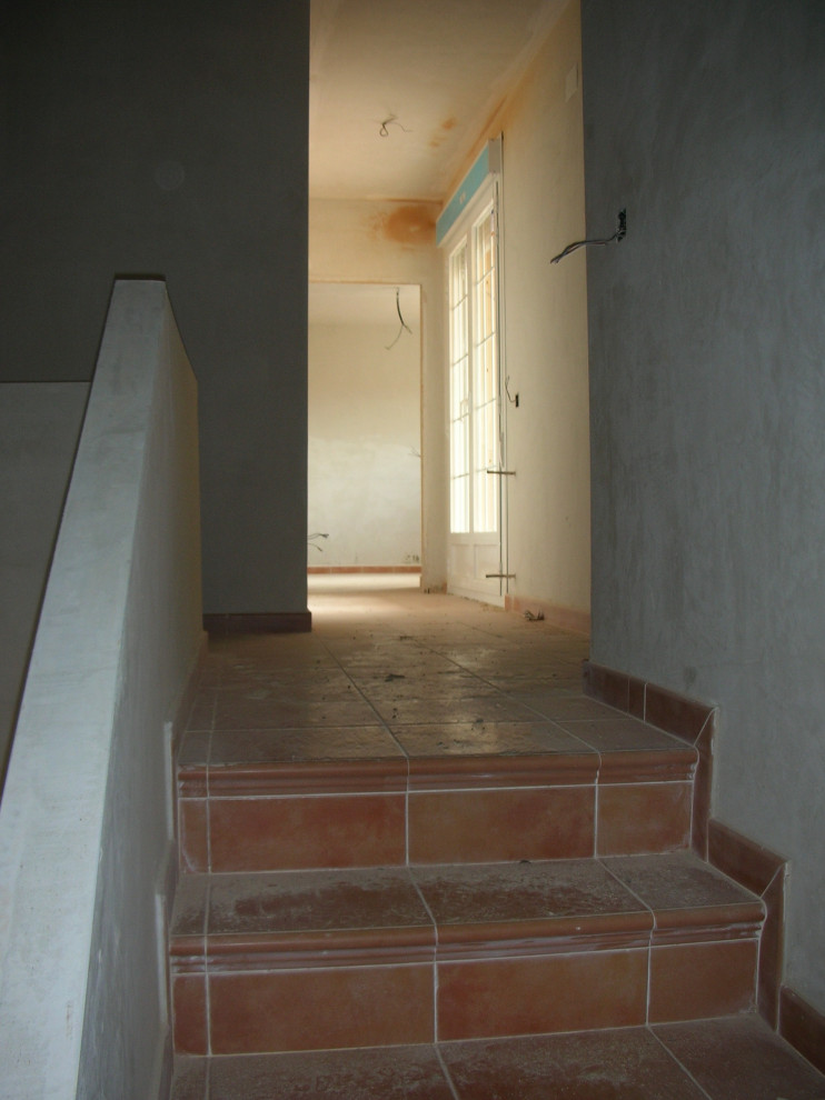 Exemple d'un escalier carrelé nature en U de taille moyenne avec des contremarches carrelées et un garde-corps en matériaux mixtes.