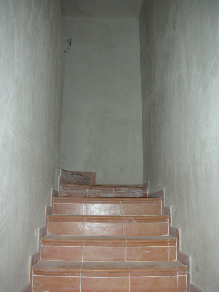 Aménagement d'un escalier carrelé campagne en U de taille moyenne avec des contremarches carrelées et un garde-corps en matériaux mixtes.