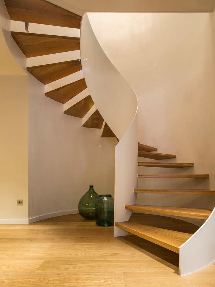 This is an example of a medium sized wood spiral staircase in Barcelona with open risers.