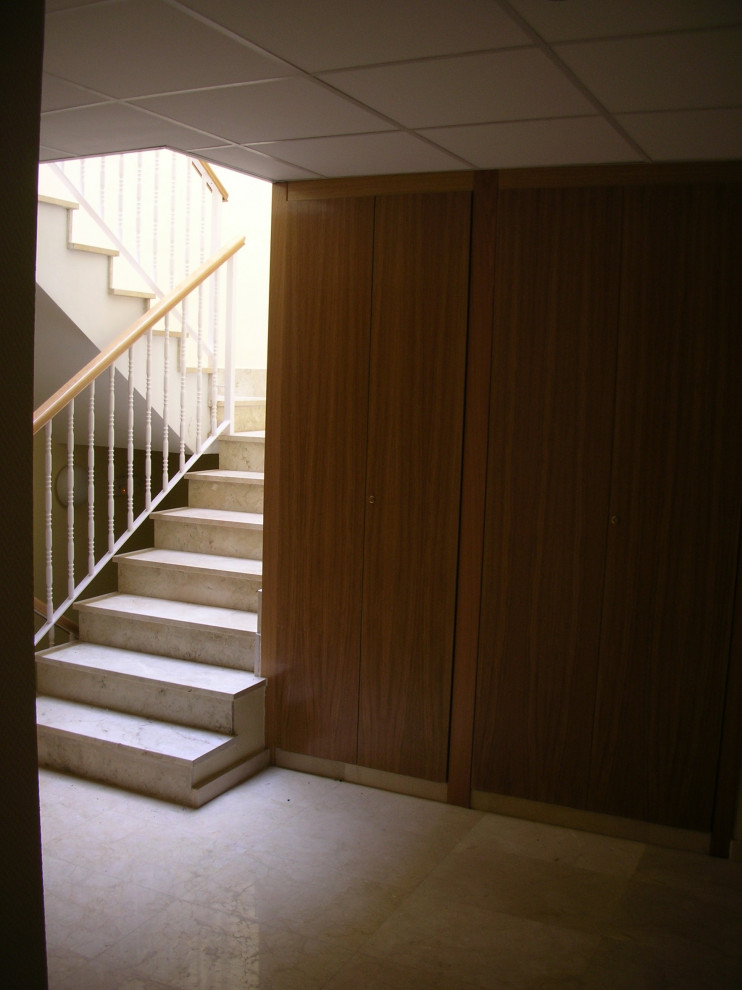 Idée de décoration pour un escalier droit minimaliste en marbre de taille moyenne avec des contremarches en marbre, un garde-corps en métal et du papier peint.