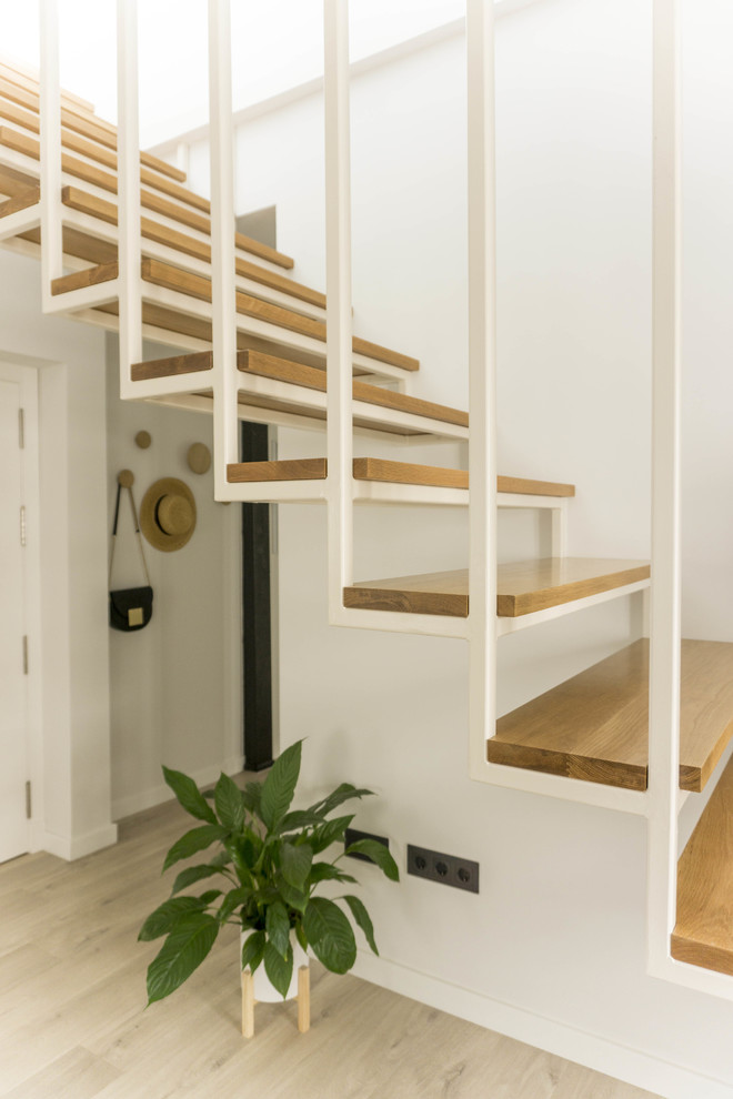 Diseño de escalera suspendida escandinava de tamaño medio con escalones de madera y barandilla de metal