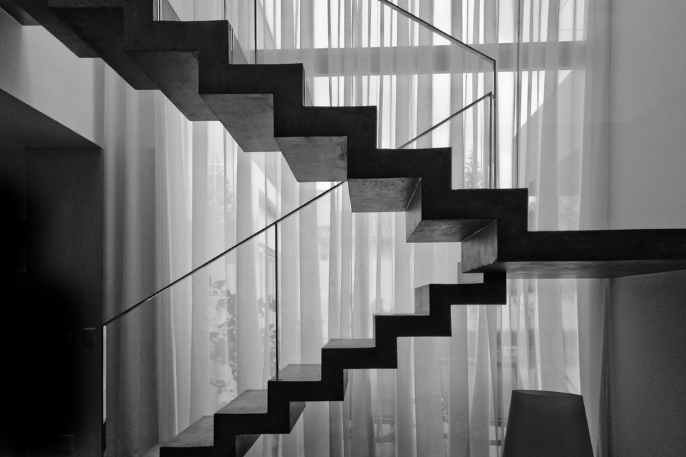 Стильный дизайн: большая п-образная бетонная лестница в стиле модернизм с бетонными ступенями и металлическими перилами - последний тренд