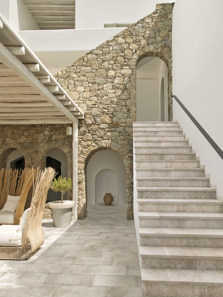 На фото: лестница среднего размера в средиземноморском стиле с ступенями из плитки и подступенками из плитки