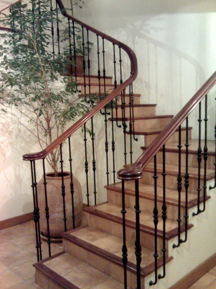 Foto de escalera en U tradicional renovada de tamaño medio con escalones con baldosas y contrahuellas con baldosas y/o azulejos