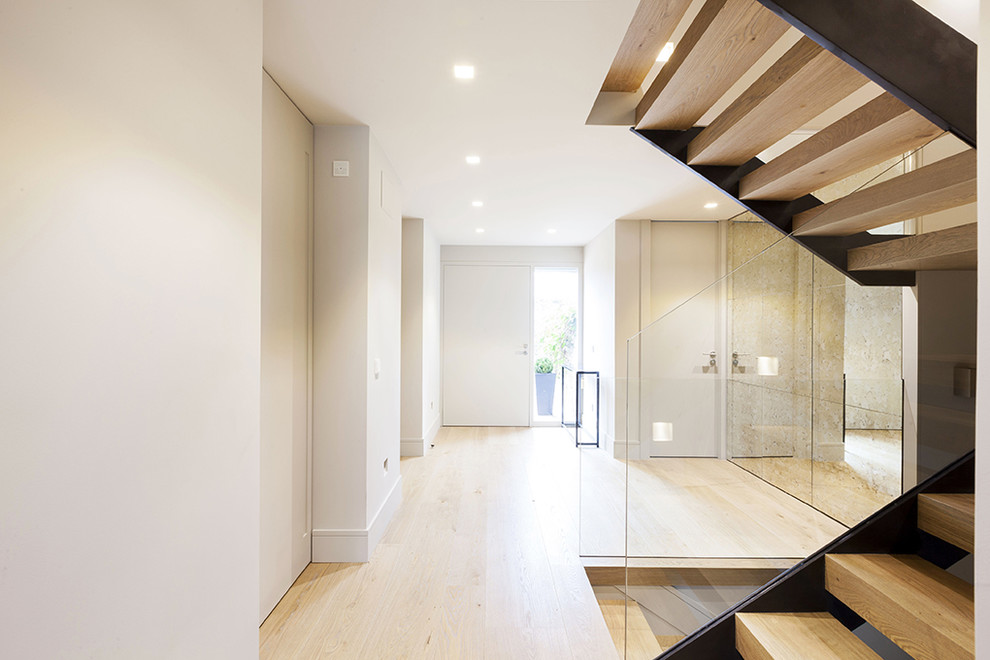 Стильный дизайн: п-образная лестница в современном стиле с деревянными ступенями и стеклянными перилами без подступенок - последний тренд