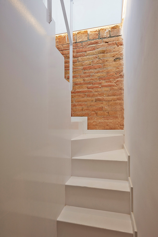 Cette image montre un escalier méditerranéen en U avec un mur en parement de brique.