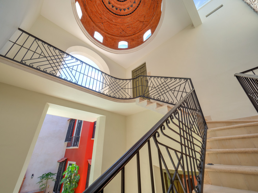 Foto de escalera en U tradicional renovada de tamaño medio con escalones de hormigón, contrahuellas con baldosas y/o azulejos y barandilla de metal
