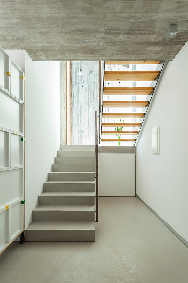 На фото: п-образная лестница среднего размера в современном стиле с бетонными ступенями без подступенок с