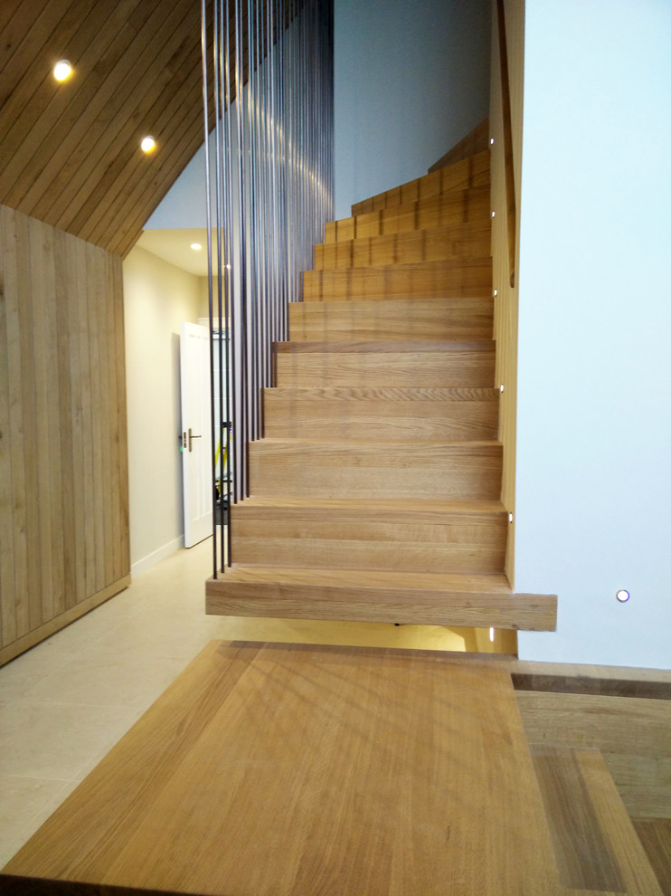 Diseño de escalera suspendida escandinava grande con escalones de madera, contrahuellas de madera y barandilla de metal