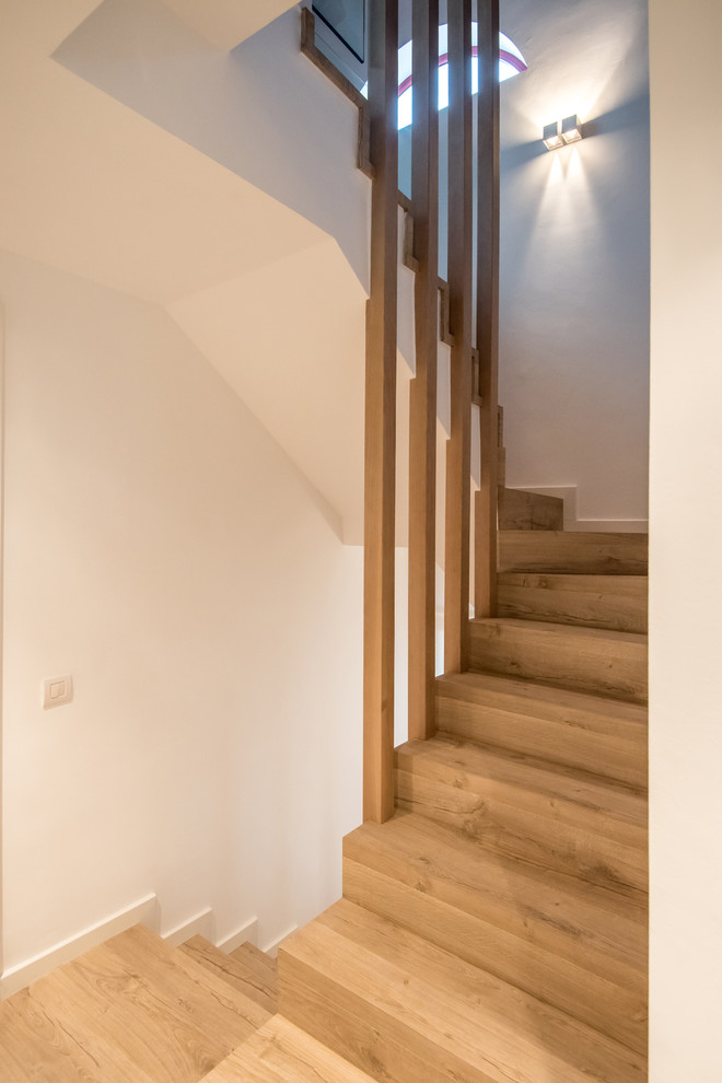 Идея дизайна: большая лестница в современном стиле с деревянными ступенями и деревянными перилами без подступенок