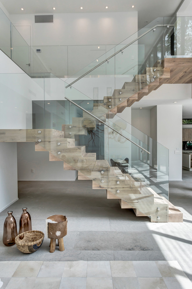 Modelo de escalera en U contemporánea con escalones de madera, contrahuellas de madera y barandilla de vidrio