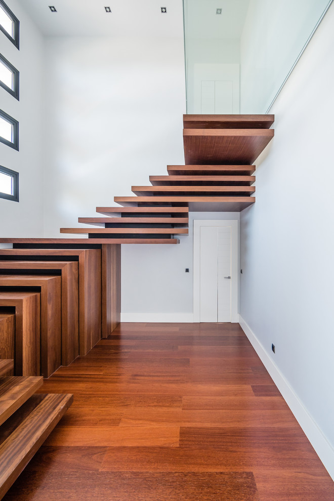 Стильный дизайн: лестница на больцах, среднего размера в современном стиле с деревянными ступенями без подступенок - последний тренд