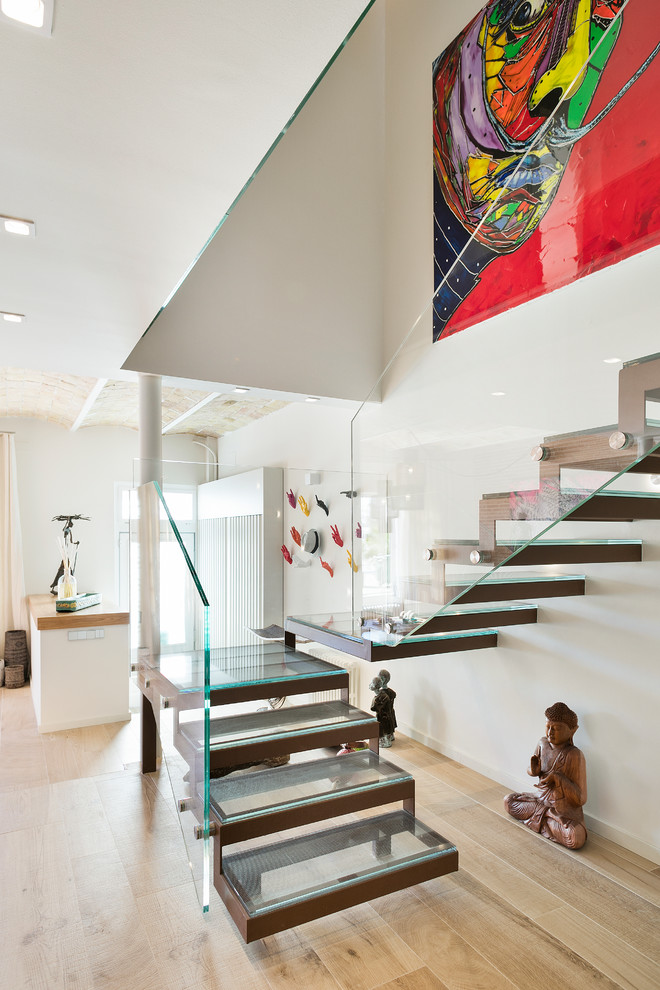 Imagen de escalera en U contemporánea grande sin contrahuella con escalones de vidrio y barandilla de vidrio