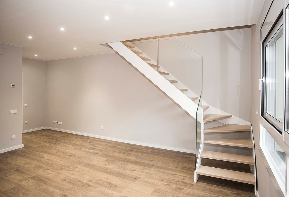 Mittelgroße Moderne Holztreppe in L-Form mit Glas-Setzstufen und Mix-Geländer in Barcelona