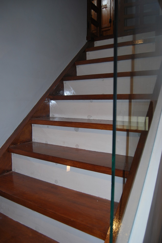 Exemple d'un grand escalier peint tendance en U avec des marches en bois et un garde-corps en verre.
