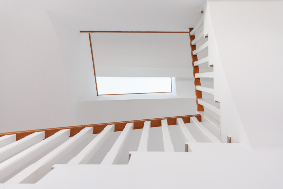 Inspiration for a mid-sized contemporary wooden u-shaped wood railing staircase remodel in Seville with concrete risers