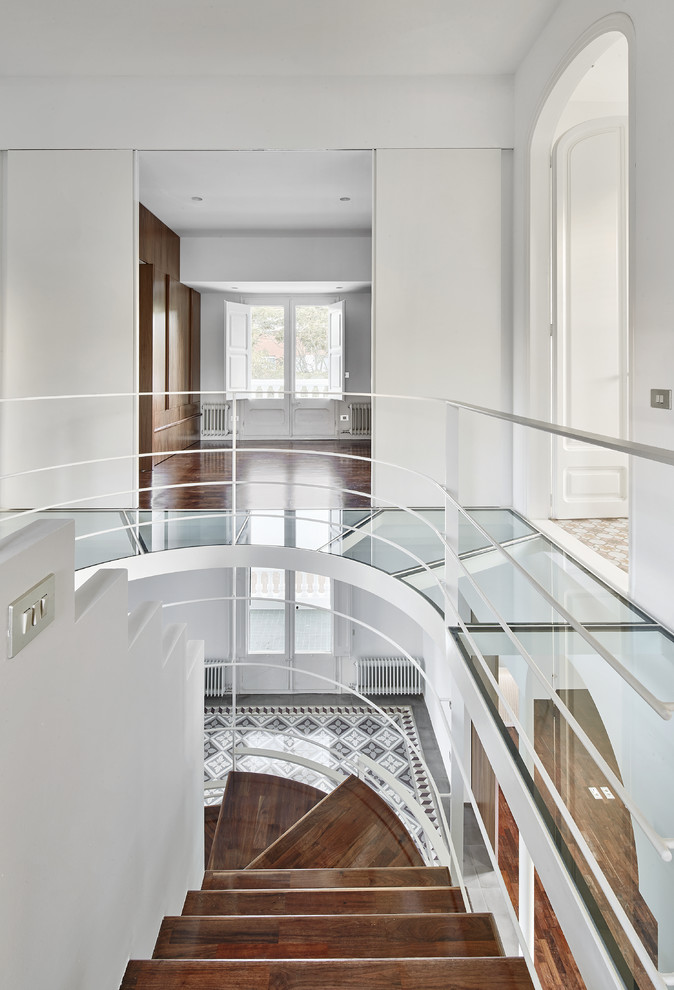 Источник вдохновения для домашнего уюта: изогнутая лестница среднего размера в стиле неоклассика (современная классика) с деревянными ступенями