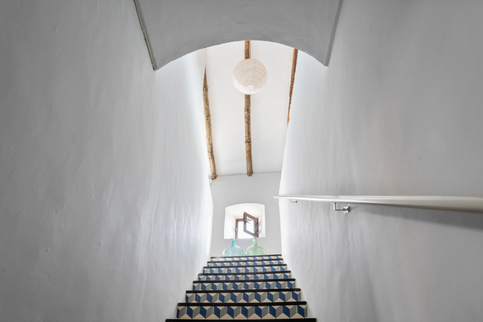 Foto de escalera recta rural pequeña con escalones de pizarra, contrahuellas con baldosas y/o azulejos, barandilla de metal y ladrillo
