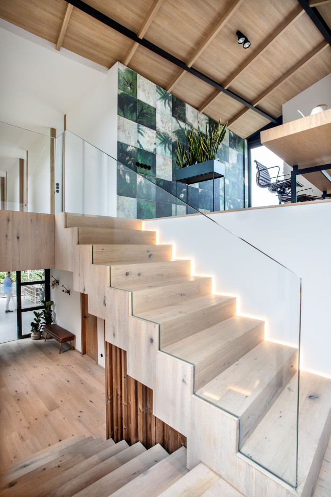 Свежая идея для дизайна: лестница в стиле модернизм с деревянными ступенями - отличное фото интерьера