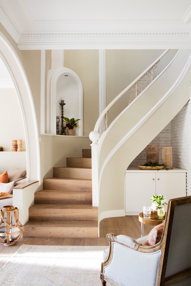 Стильный дизайн: изогнутая деревянная лестница в морском стиле с деревянными ступенями - последний тренд