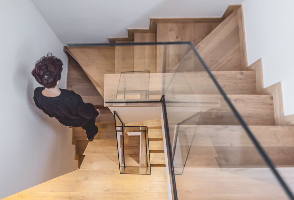 Diseño de escalera actual con escalones de madera y barandilla de vidrio