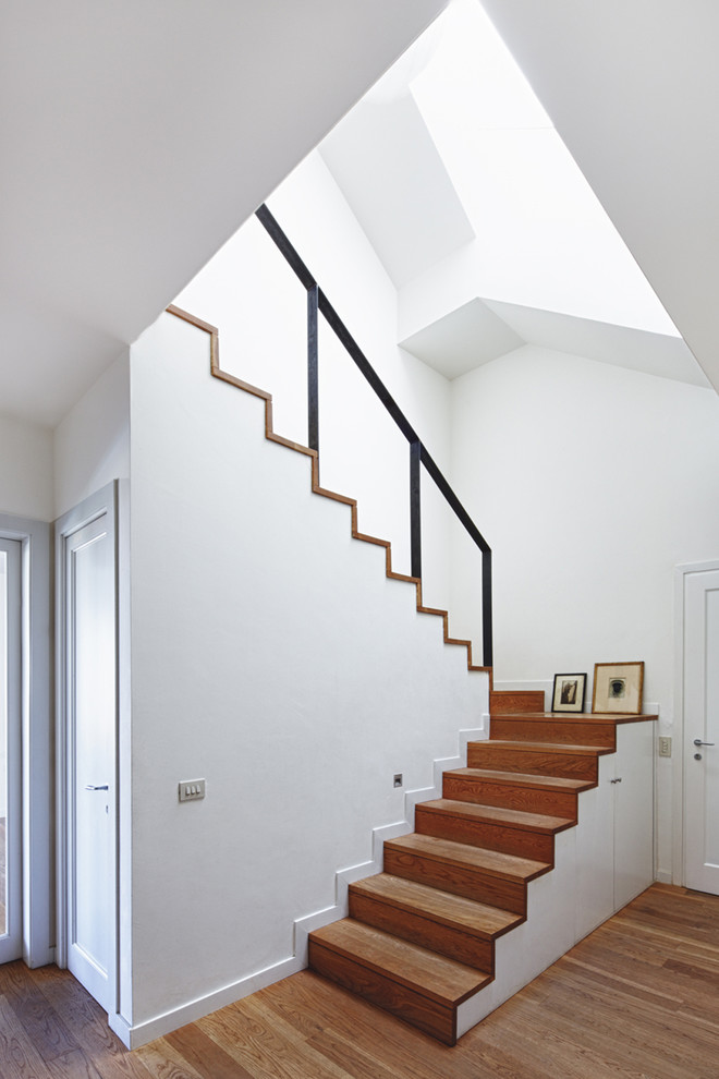 Imagen de escalera en U escandinava de tamaño medio con escalones de madera, contrahuellas de madera y barandilla de metal