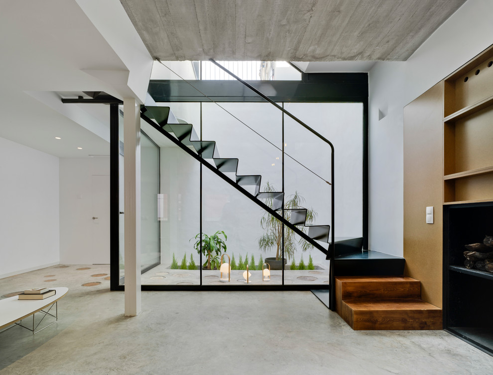 На фото: угловая металлическая лестница среднего размера в стиле модернизм с металлическими ступенями и металлическими перилами с