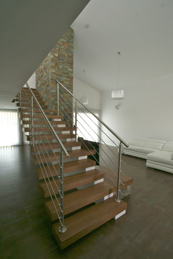 Design ideas for a medium sized contemporary wood straight staircase in Madrid with open risers.