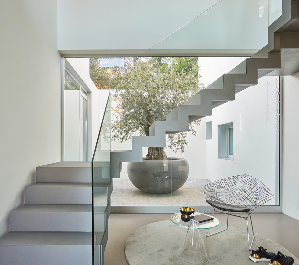 バルセロナにあるコンテンポラリースタイルのおしゃれな折り返し階段 (ガラスフェンス) の写真