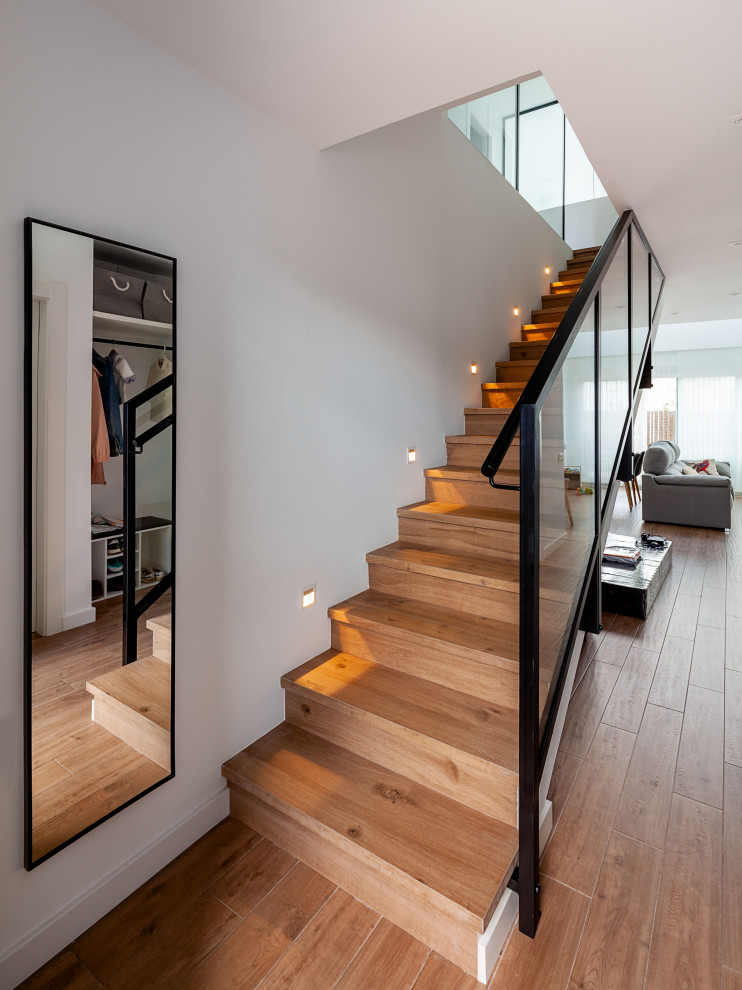 Diseño de escalera recta contemporánea de tamaño medio con escalones de madera, contrahuellas de madera y barandilla de varios materiales