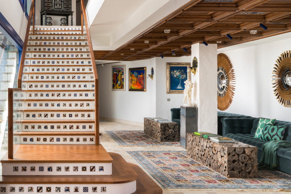 Modelo de escalera recta mediterránea grande con escalones de madera, contrahuellas con baldosas y/o azulejos y barandilla de varios materiales
