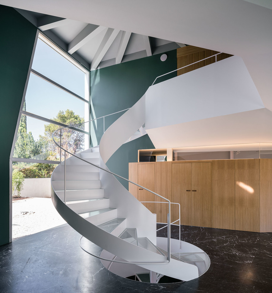 На фото: винтовая лестница в современном стиле с стеклянными ступенями, ковровыми подступенками и металлическими перилами