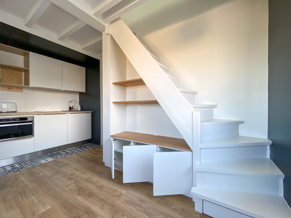 Idée de décoration pour un petit escalier peint droit design avec des marches en bois peint et un garde-corps en bois.