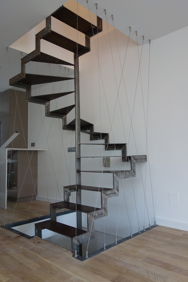Design ideas for a large urban metal spiral staircase in Paris with open risers.