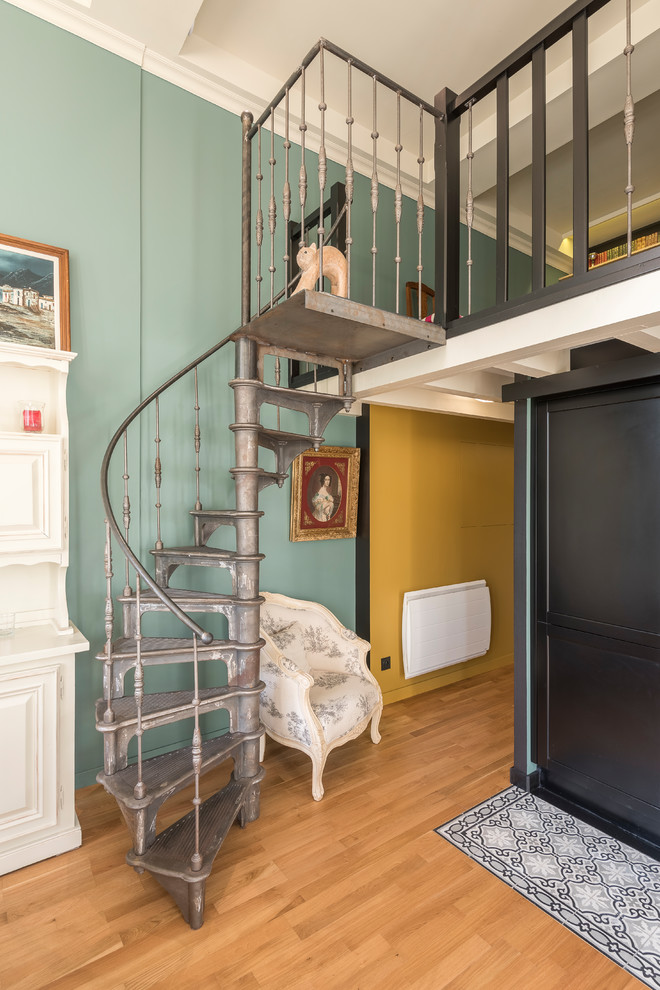 Foto de escalera de caracol bohemia sin contrahuella con escalones de metal y barandilla de metal