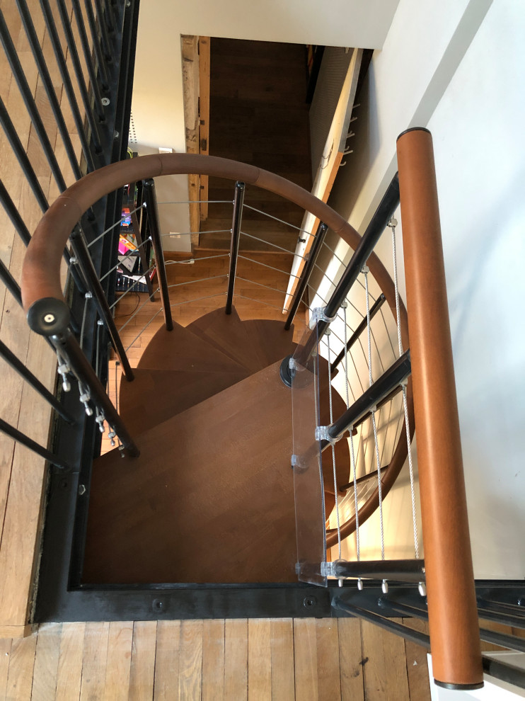 Diseño de escalera de caracol actual de tamaño medio con escalones de madera y barandilla de metal