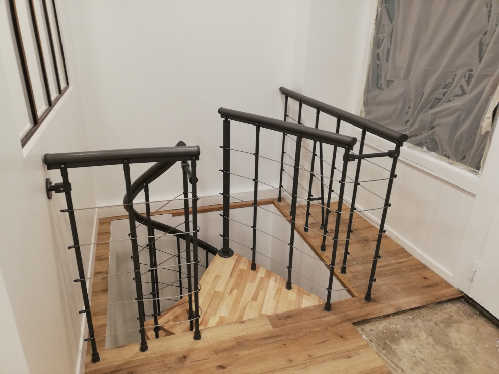 На фото: маленькая винтовая лестница в современном стиле с деревянными ступенями и перилами из тросов для на участке и в саду с