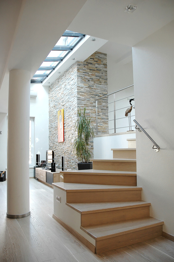 Свежая идея для дизайна: изогнутая деревянная лестница среднего размера в современном стиле с деревянными ступенями - отличное фото интерьера