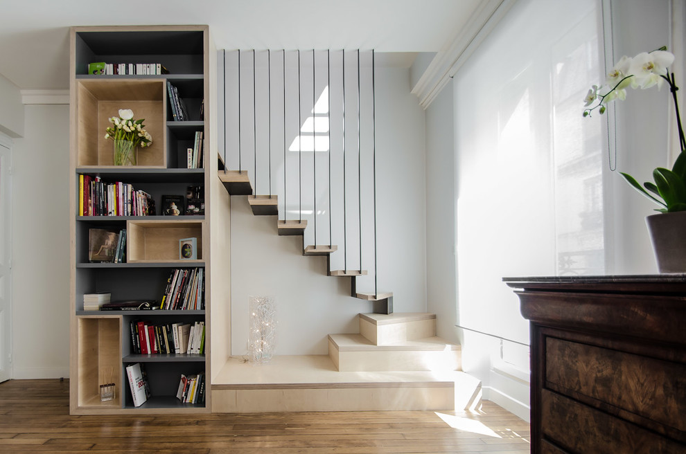 Idée de décoration pour un escalier design en L de taille moyenne avec des marches en bois, des contremarches en métal et rangements.