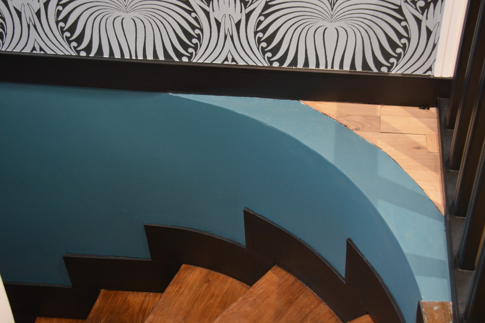 Imagen de escalera de caracol actual de tamaño medio con escalones de madera, contrahuellas de madera y barandilla de madera