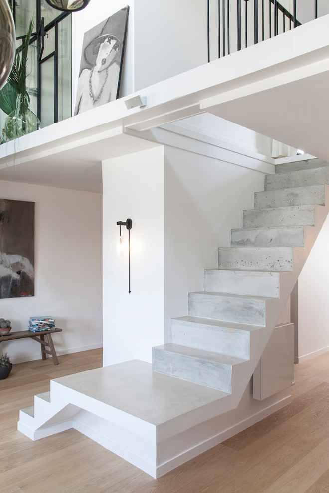 Inspiration for a contemporary concrete staircase remodel in Paris with concrete risers