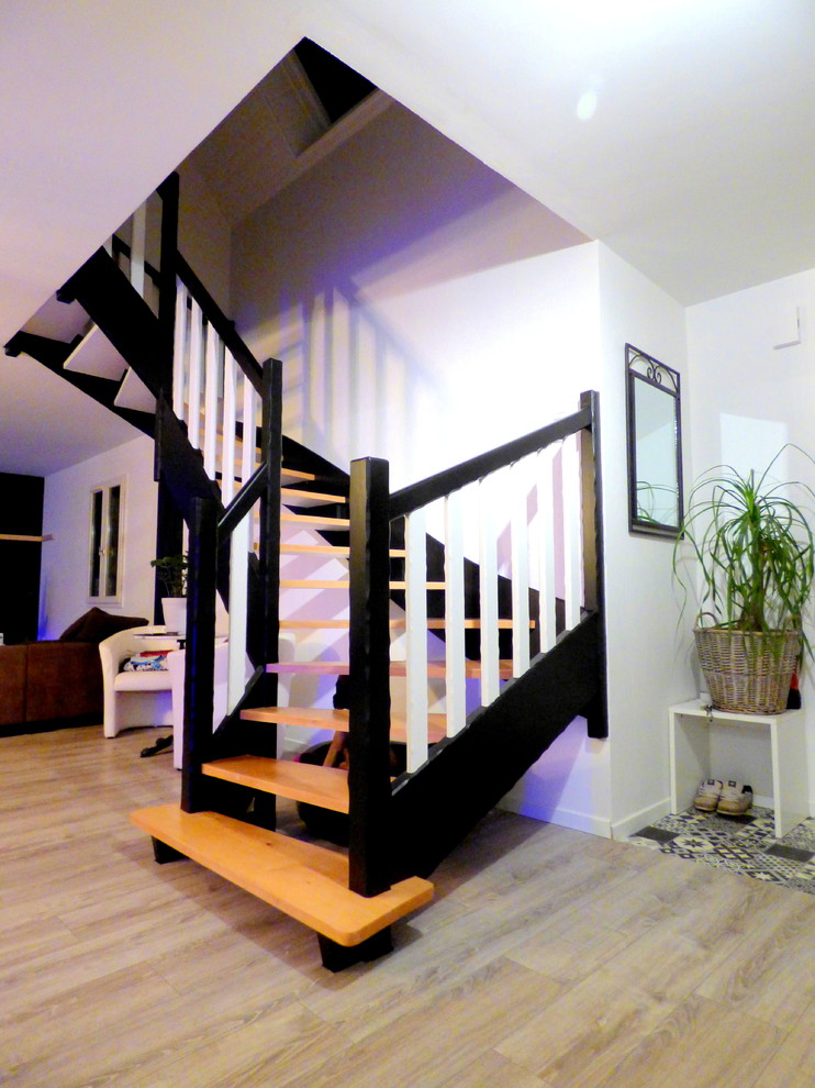 Photo of a large modern wood u-shaped wood railing staircase in Other.
