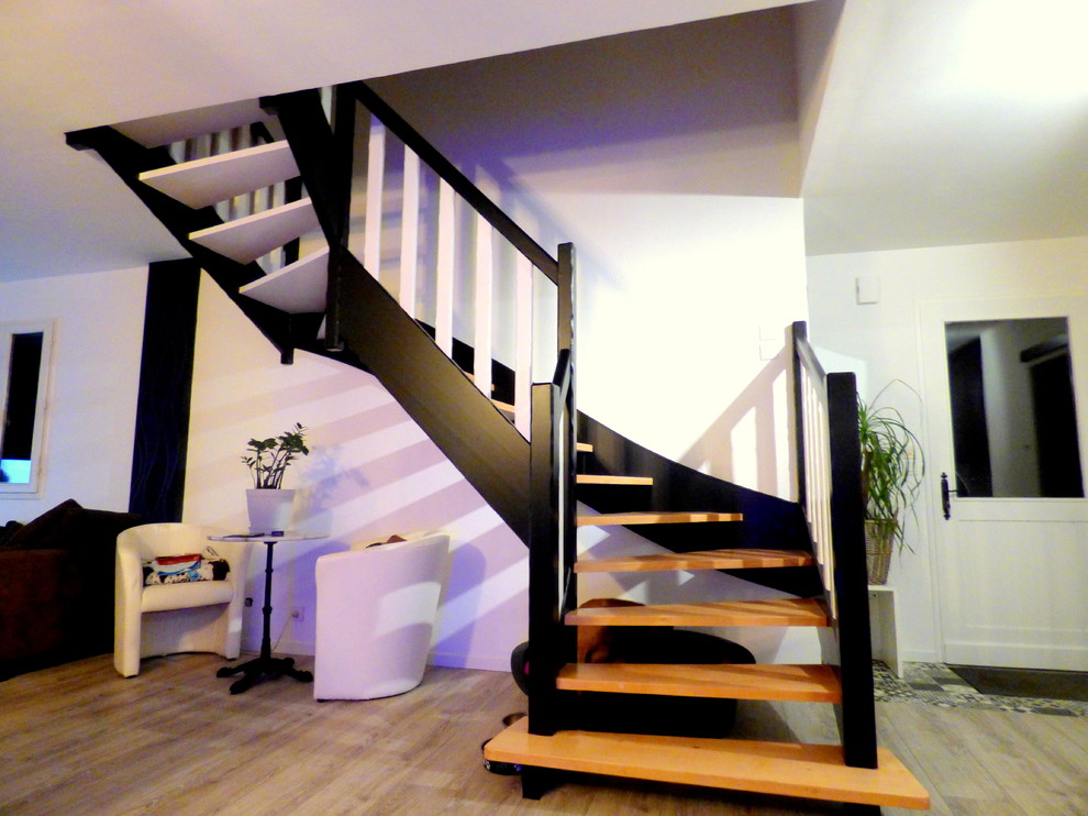 На фото: большая п-образная лестница в стиле модернизм с деревянными ступенями и деревянными перилами с