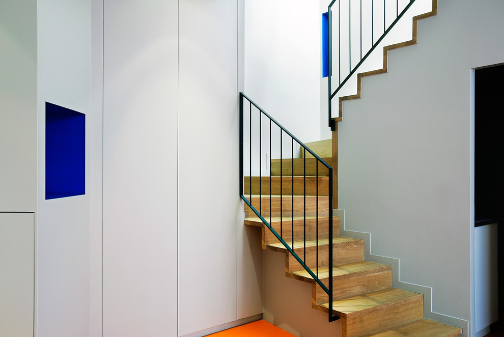 Foto de escalera curva contemporánea de tamaño medio con escalones de madera, contrahuellas de madera y barandilla de metal